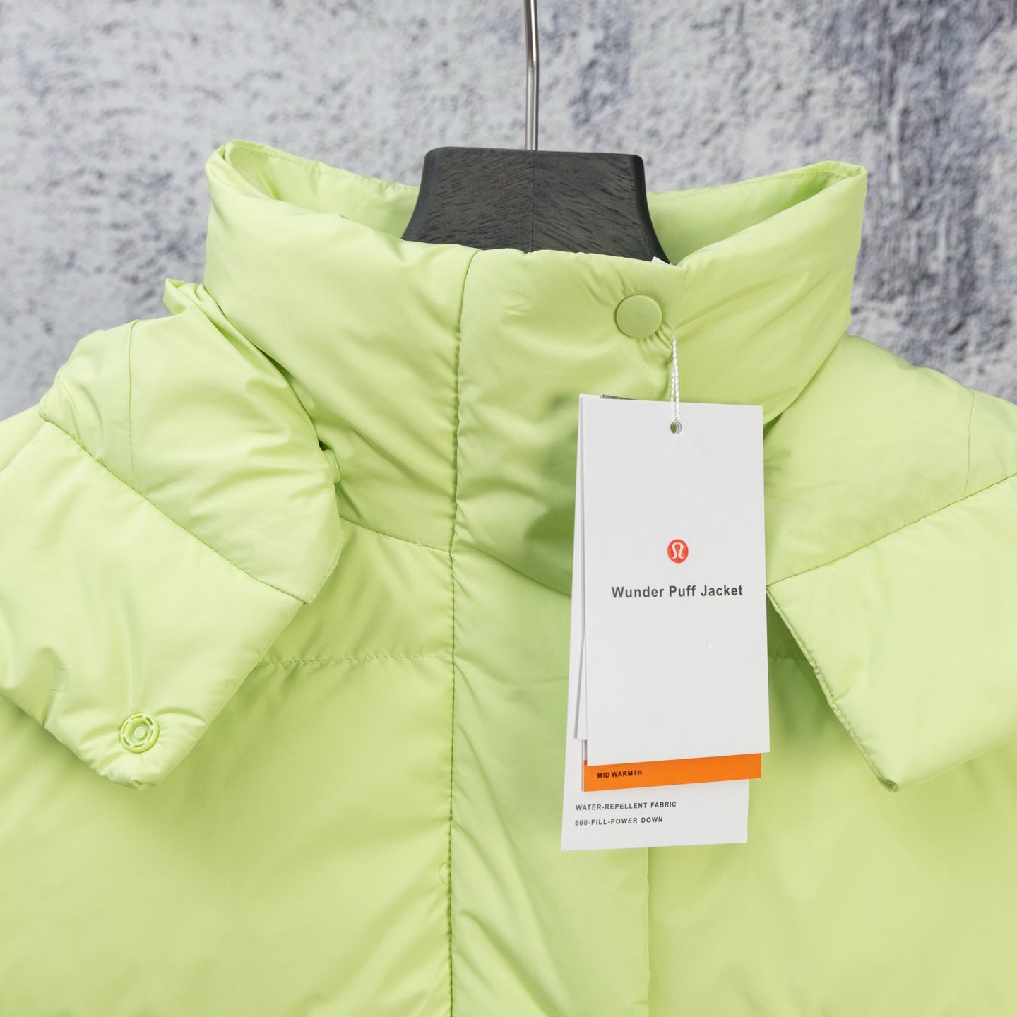 Lime green puffer jacket with buttoned high collar and hanging product tag