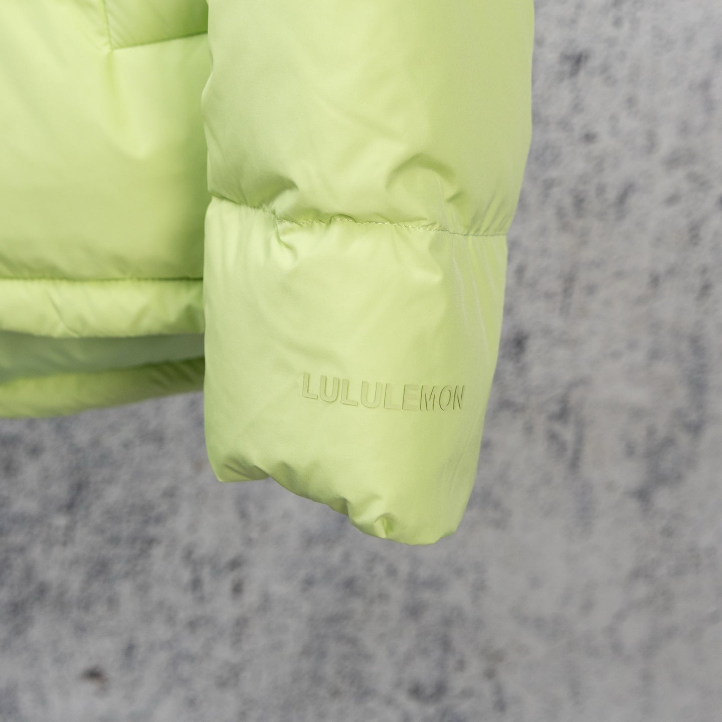 Lime green puffer jacket cuff with LULULEMON logo print