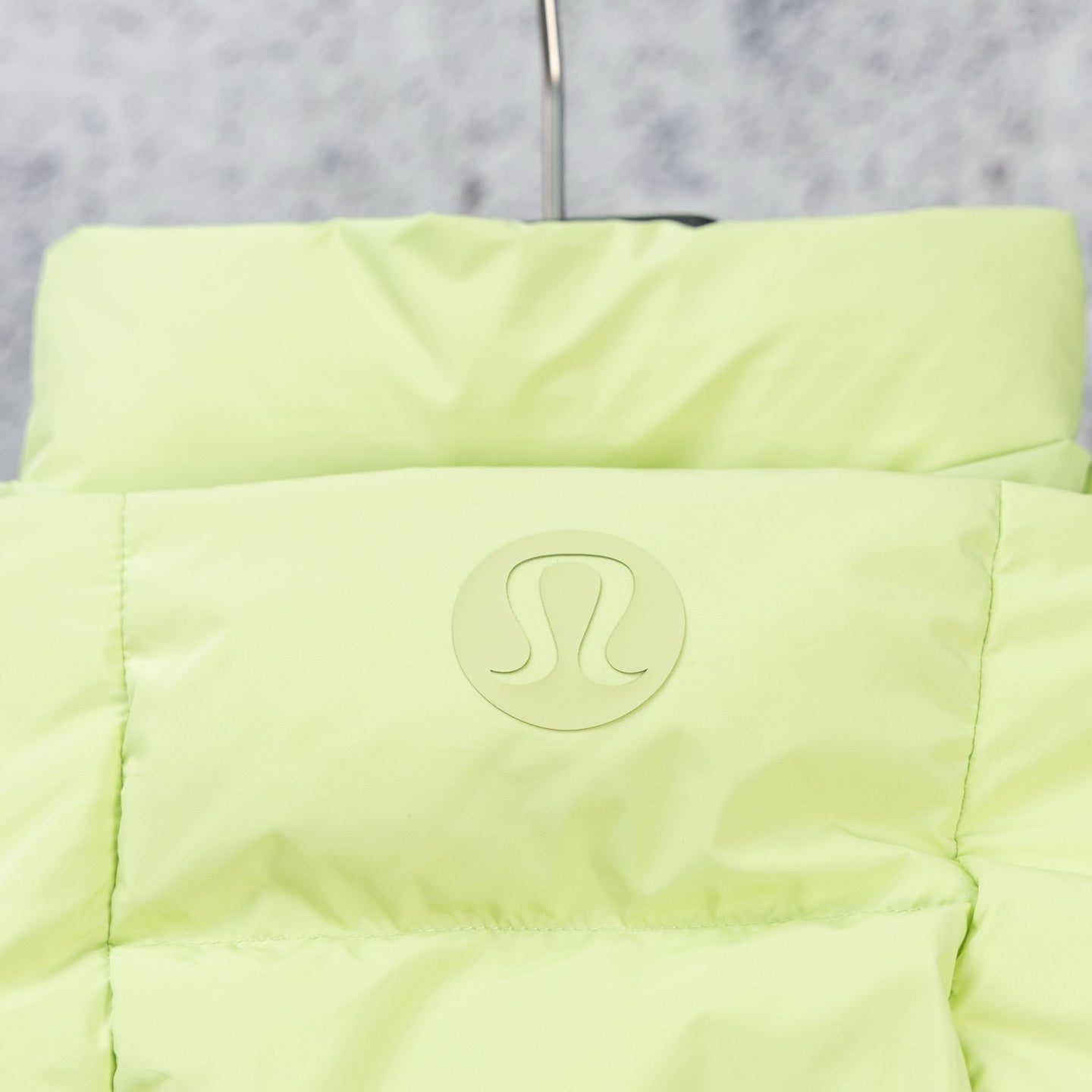 Light green hooded puffer jacket with circular chest logo