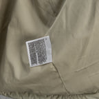 Beige puffer jacket front with sewn care label on chest