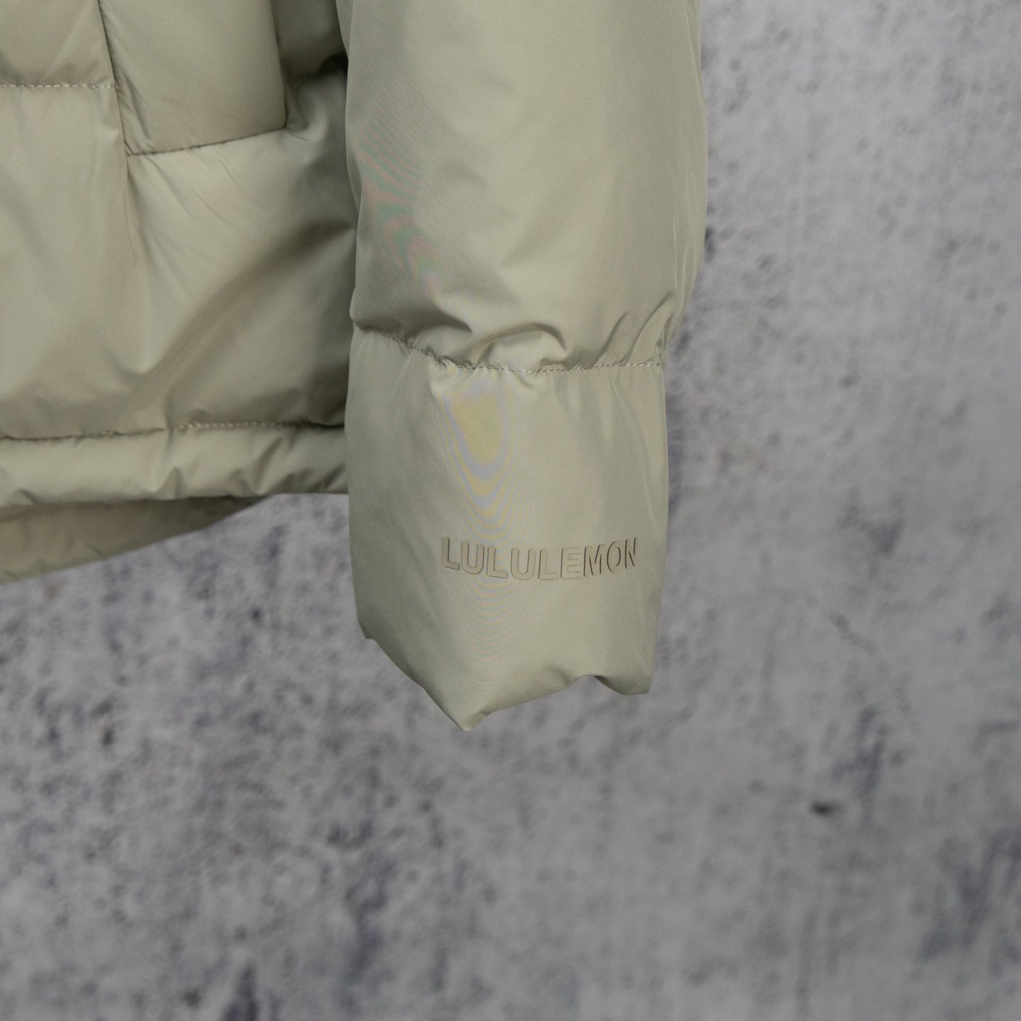 Light olive puffer jacket sleeve cuff with LULULEMON label