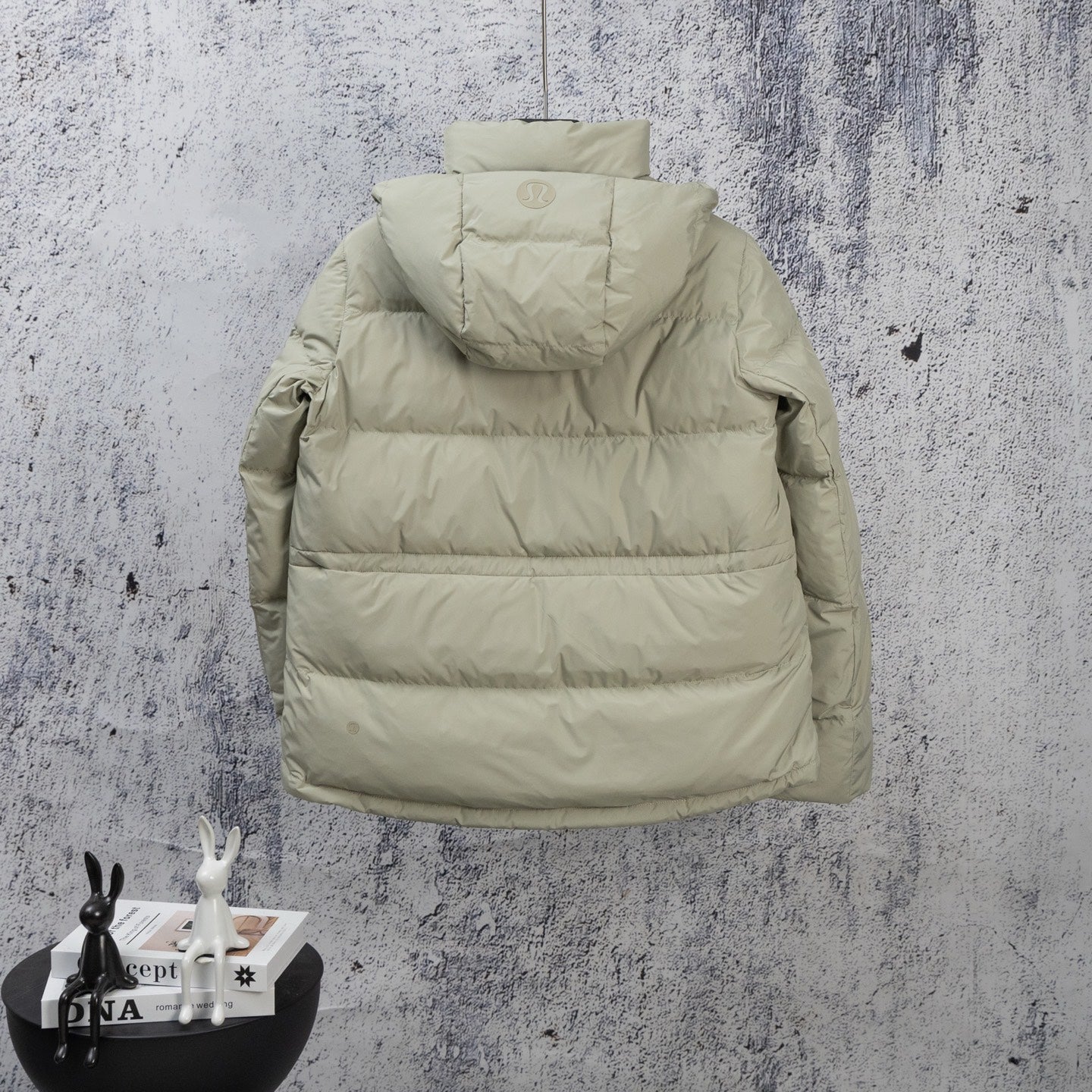 Light olive puffer jacket with attached hood and horizontal quilted panels