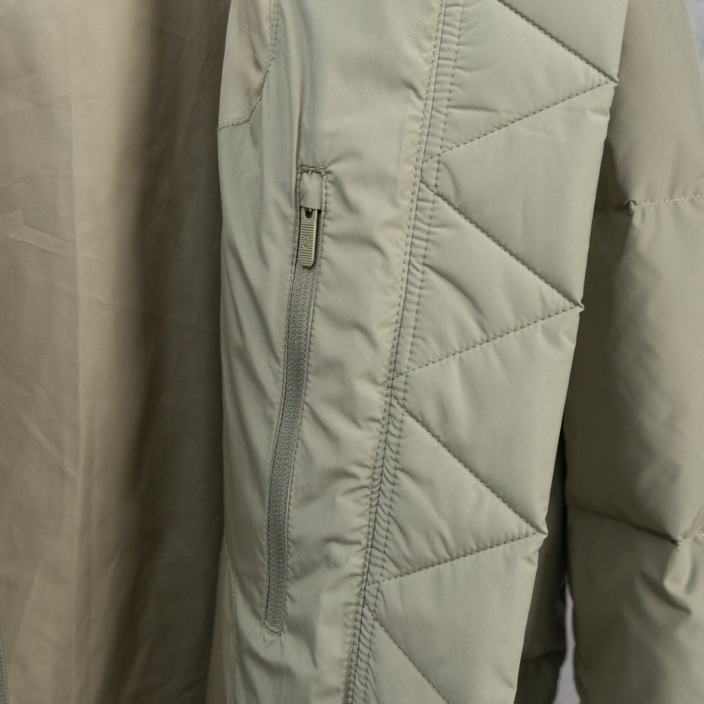 Beige puffer jacket with diagonal quilting and front zipper