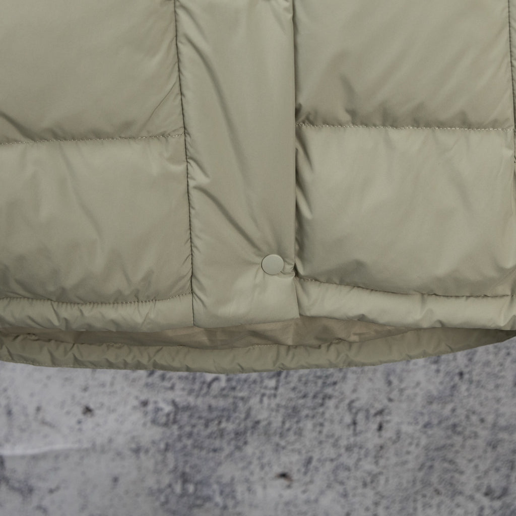 Light olive puffer jacket hem with center button and quilted panel seams