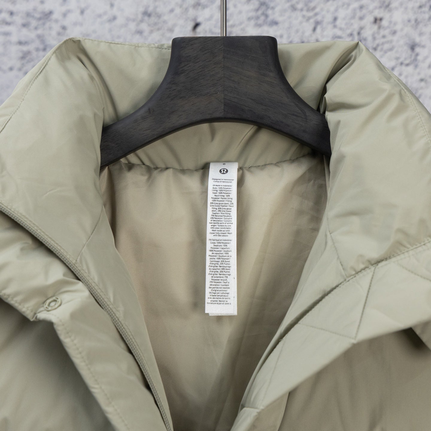 Light olive puffer jacket hood lining with hanging care tag