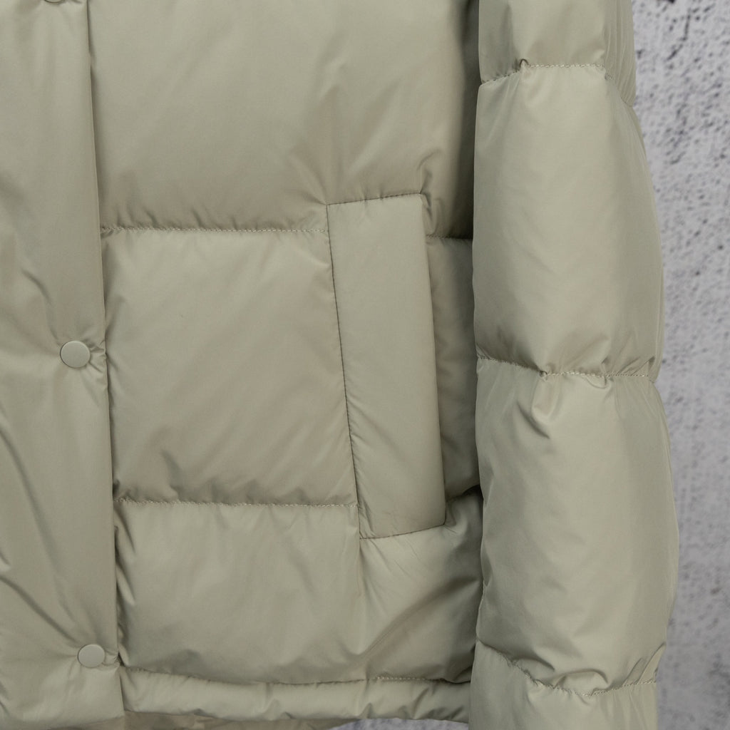 Light olive puffer jacket interior view with quilted panels and sleeve cuff