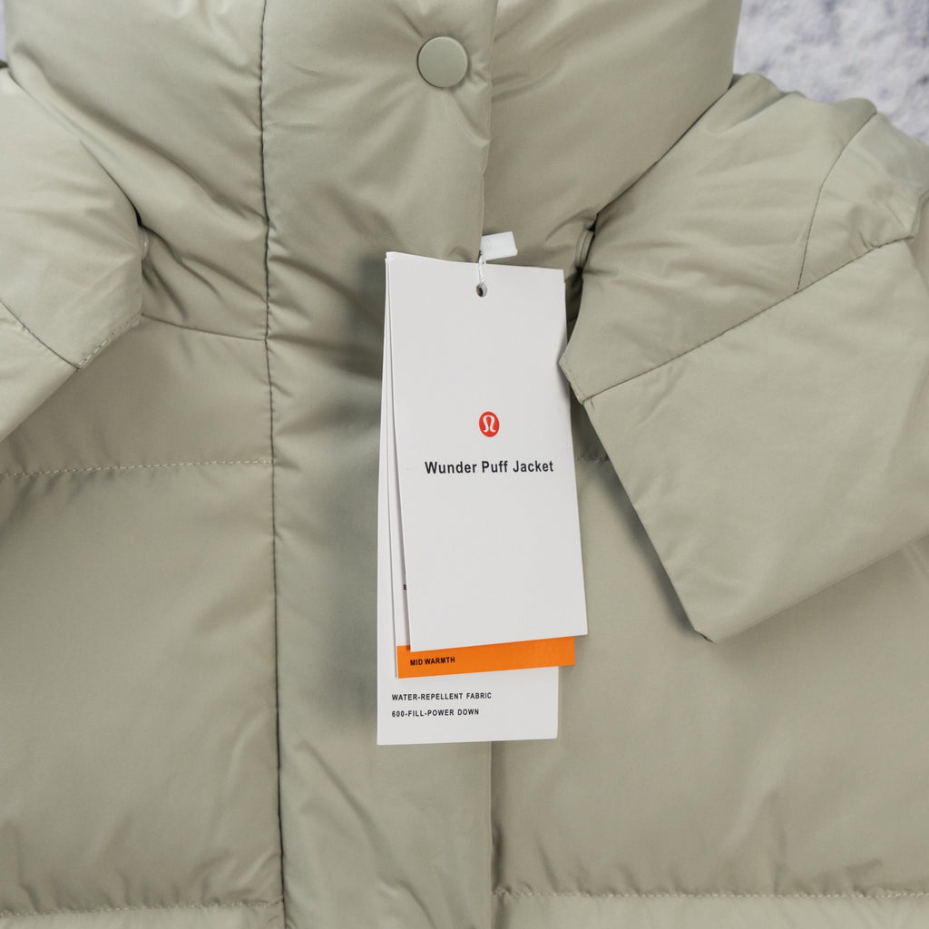 Light olive hooded puffer jacket with button placket and hanging product tag