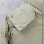 Light olive puffer jacket sleeve with metal snap button and stitched panel seams