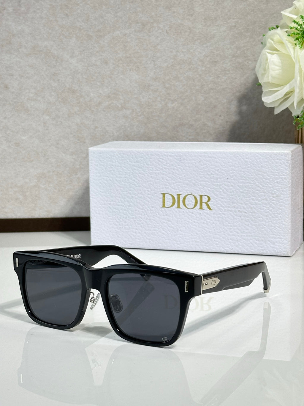 Dior sunglasses with black frames and dark gray lenses, side profile