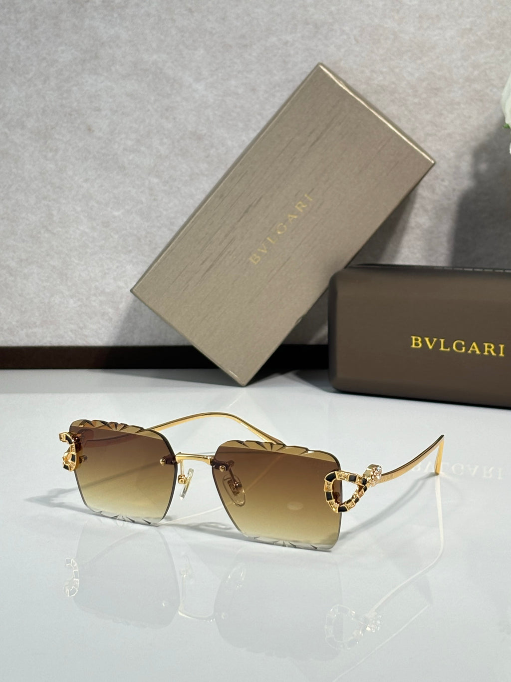 Bvlgari sunglasses with brown tinted lenses and gold frame with jeweled temple details