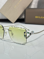 Bvlgari sunglasses close-up with light green tinted lenses and silver jeweled frame