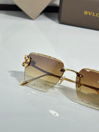 Bvlgari sunglasses side view with amber tinted lens and gold frame and hinge detail