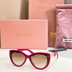 MiuMiu cat-eye sunglasses with magenta frames and light-tinted lenses.