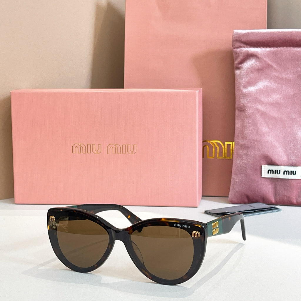 MiuMiu cat-eye sunglasses with black frames and amber-tinted lenses.