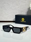 Rectangular sunglasses with black frames, dark lenses, gold logo detail on temple
