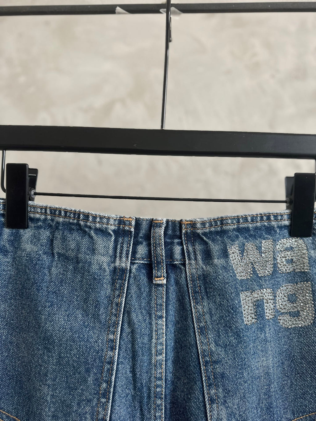 Light blue denim pants, button-and-zip front, waistband logo print