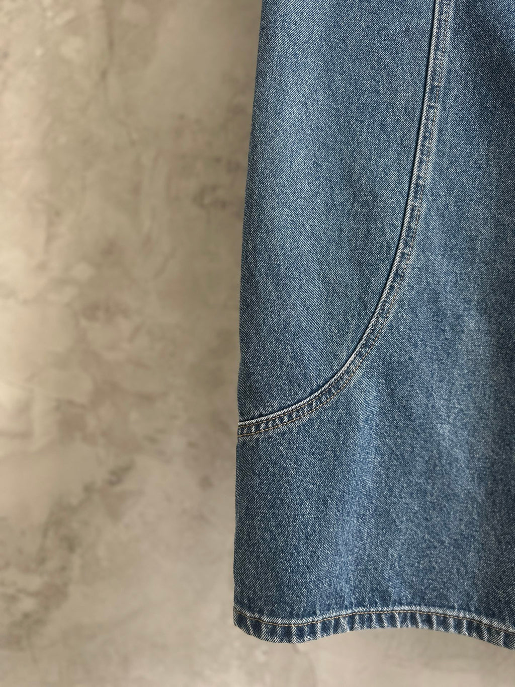 Light blue denim pant side seam and curved hem