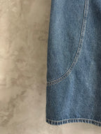Light blue denim pant side seam and curved hem