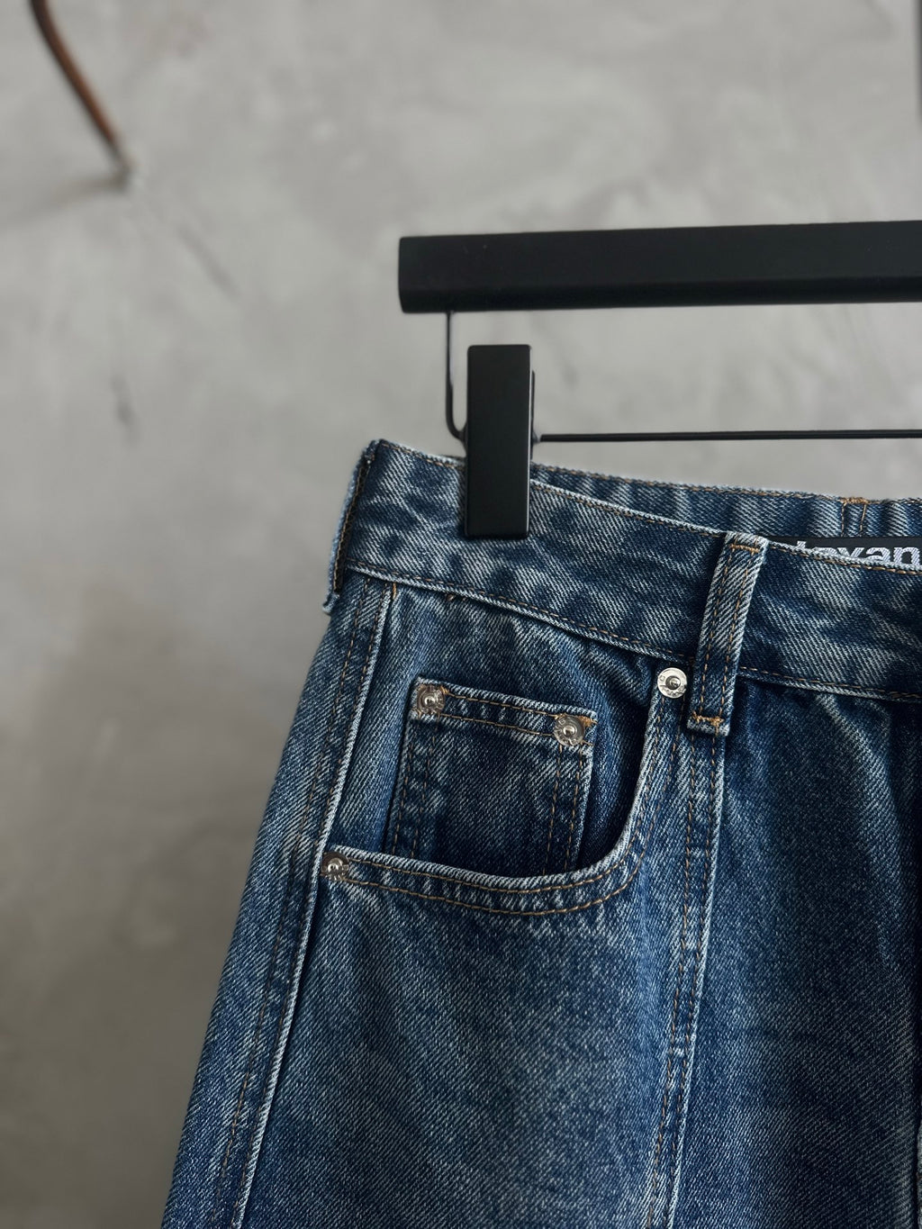 Blue denim pants with front pockets and metal-button closure