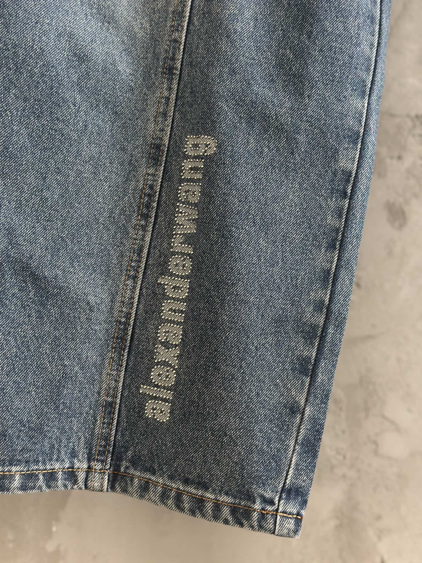 Blue denim pants with vertical “alexanderwang” logo label on side