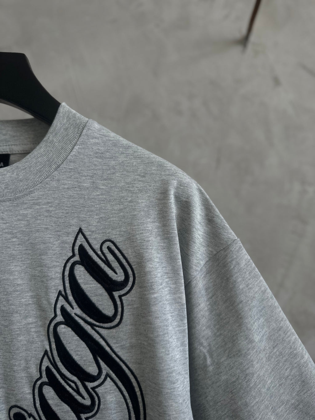 Gray T-shirt close-up of Balenciaga script logo on sleeve