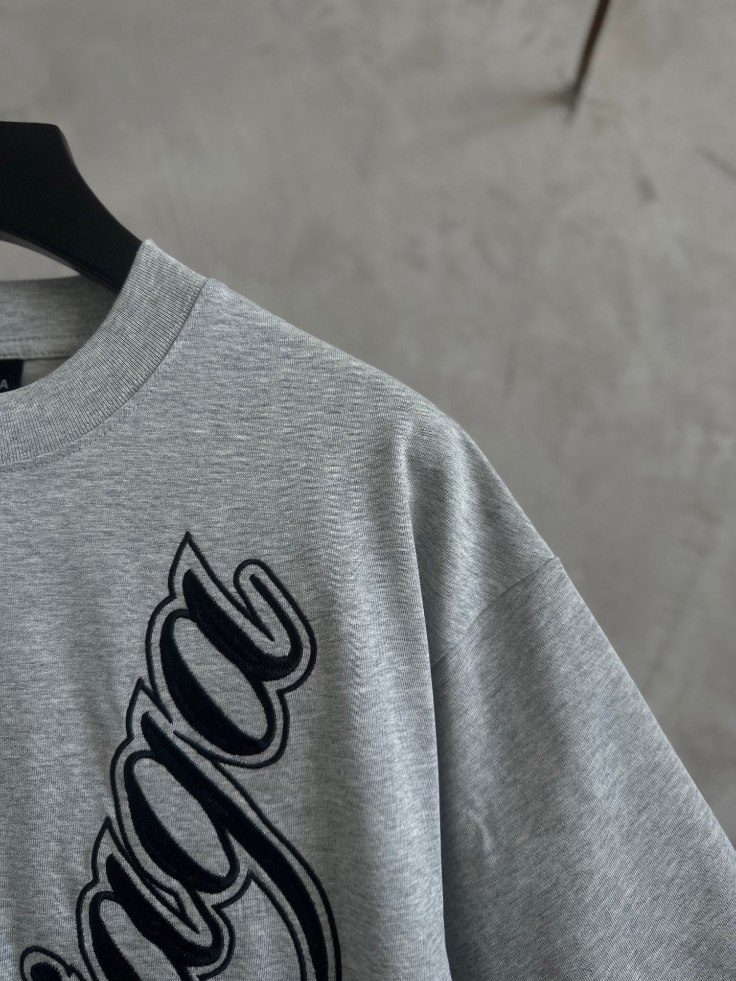 Gray T-shirt close-up of Balenciaga script logo on sleeve