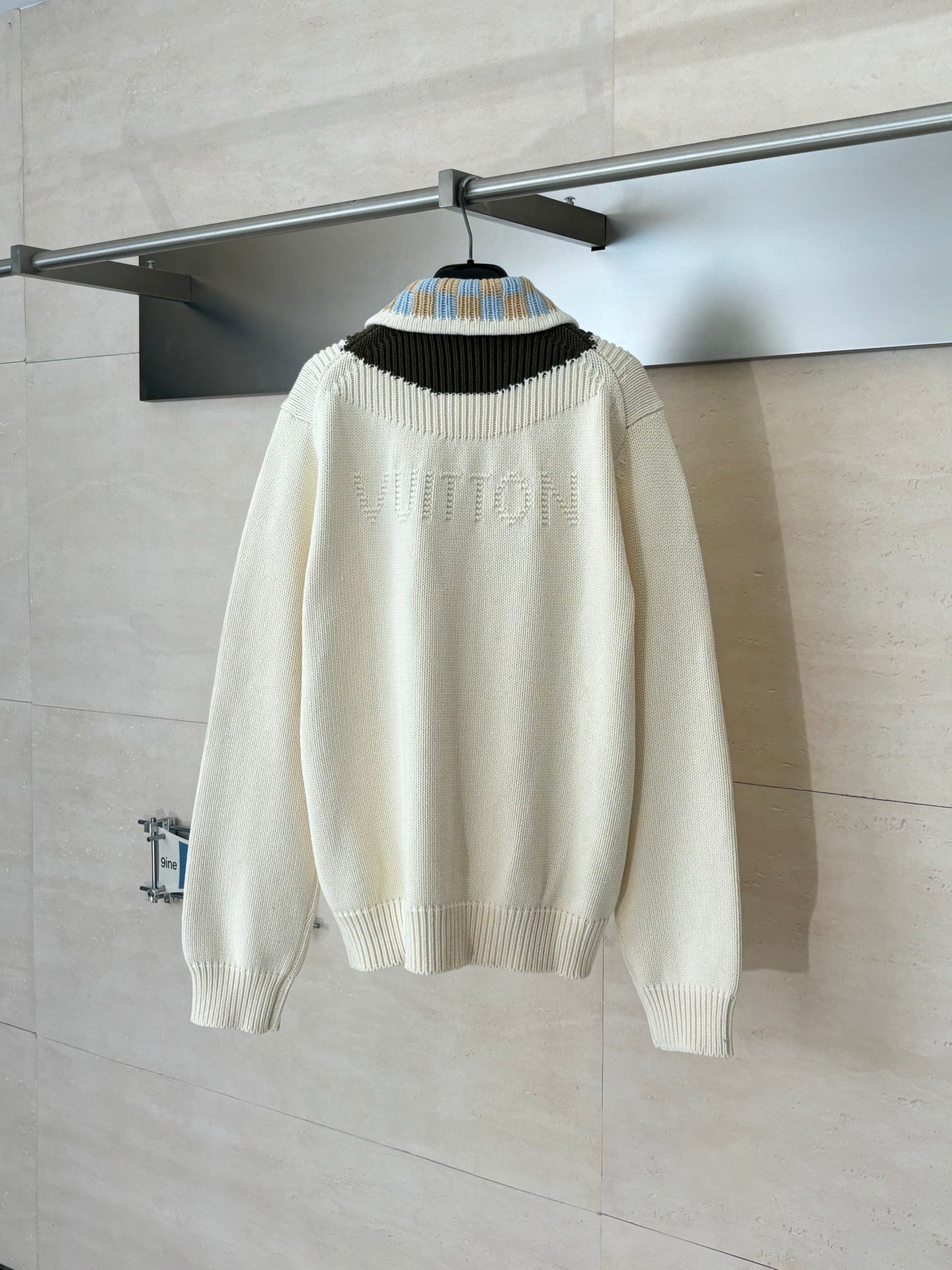 White knit sweater with striped collar and ribbed cuffs, viewed from the back
