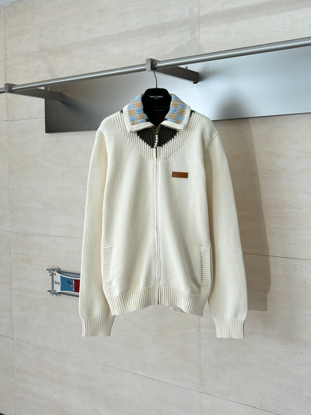 White knit sweater with striped collar, black yoke, and zip-front detail