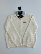 White zip-front knit sweater with striped shoulders and black collar yoke