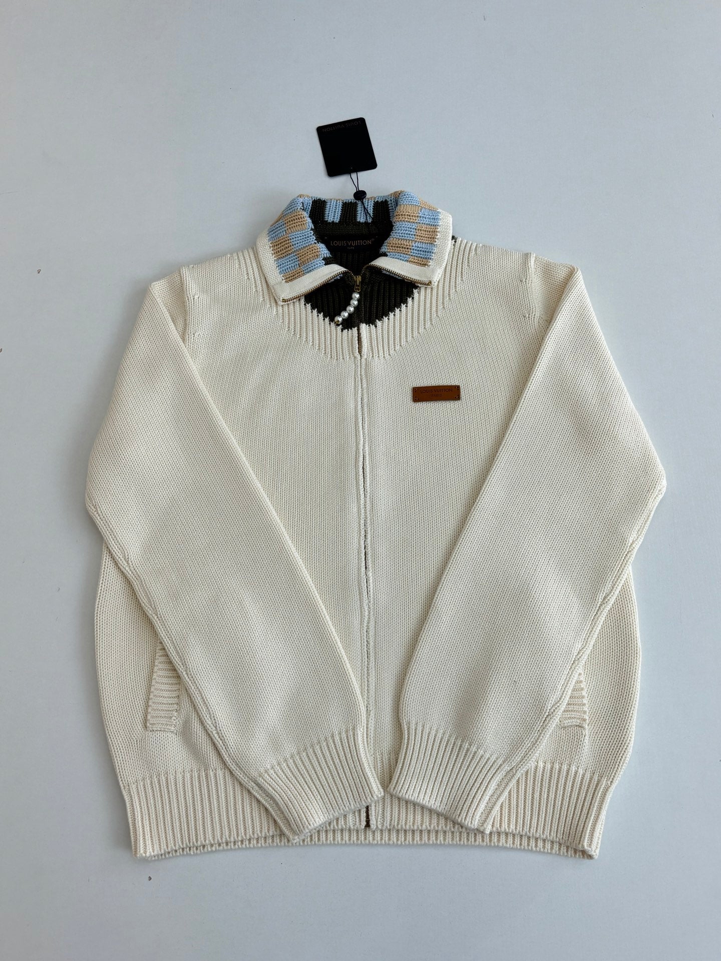 White zip-front knit sweater with striped shoulders and black collar yoke