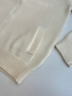 White knit sweater sleeve and hem with ribbed cuffs and textured stitch detail