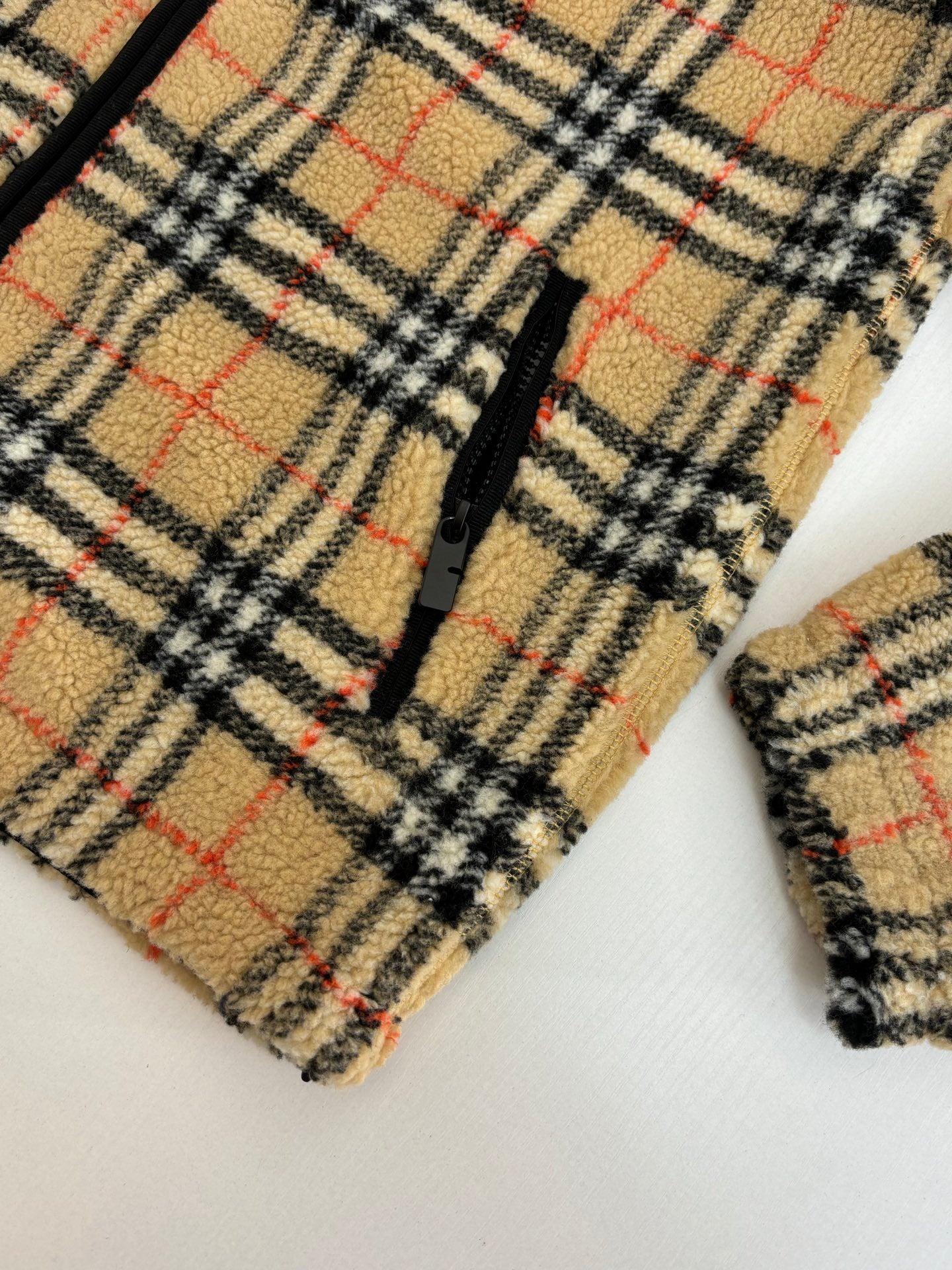 Plaid jacket sleeve cuff detail with black zip edge