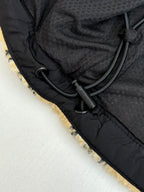 Black drawcord and zipper hardware on jacket interior lining edge