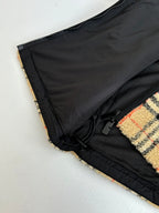 Black mesh lining panel and black drawcord along plaid jacket edge