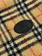 Round Burberry logo patch on plaid sherpa lining fabric