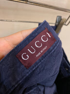 Gucci pants label close-up, burgundy tag with Gucci and Made in Italy