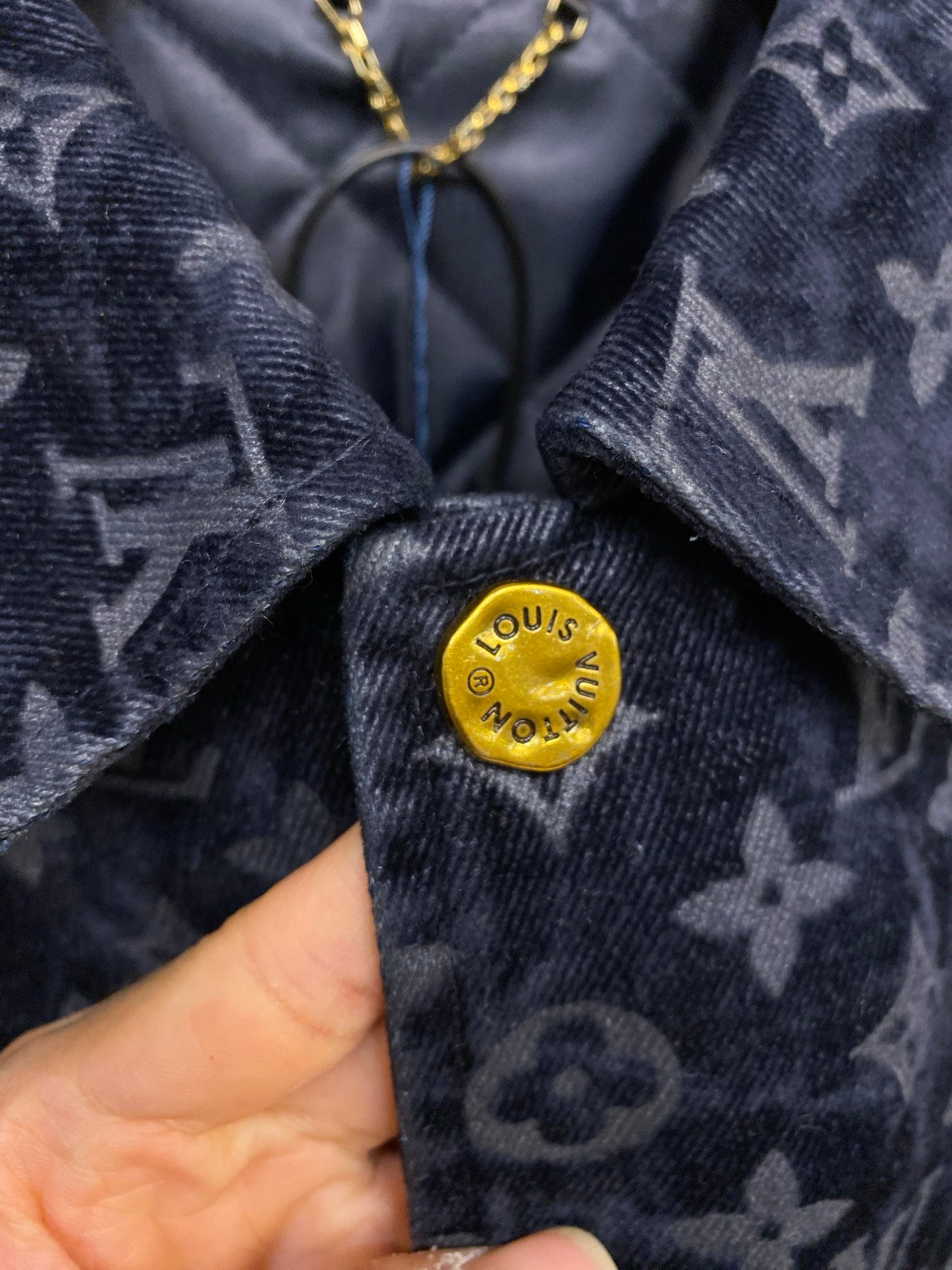 Louis Vuitton gold logo button on navy monogram jacket fabric