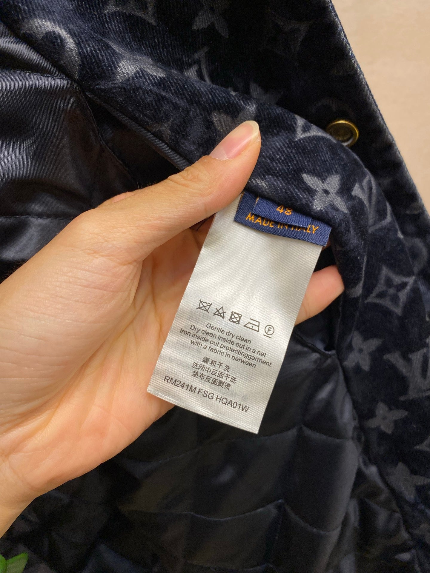 Care label and blue brand tag on navy Louis Vuitton quilted jacket lining