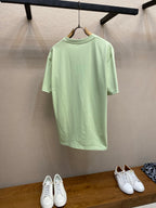 Light green Dior crewneck T-shirt on a hanger, back view with straight hem