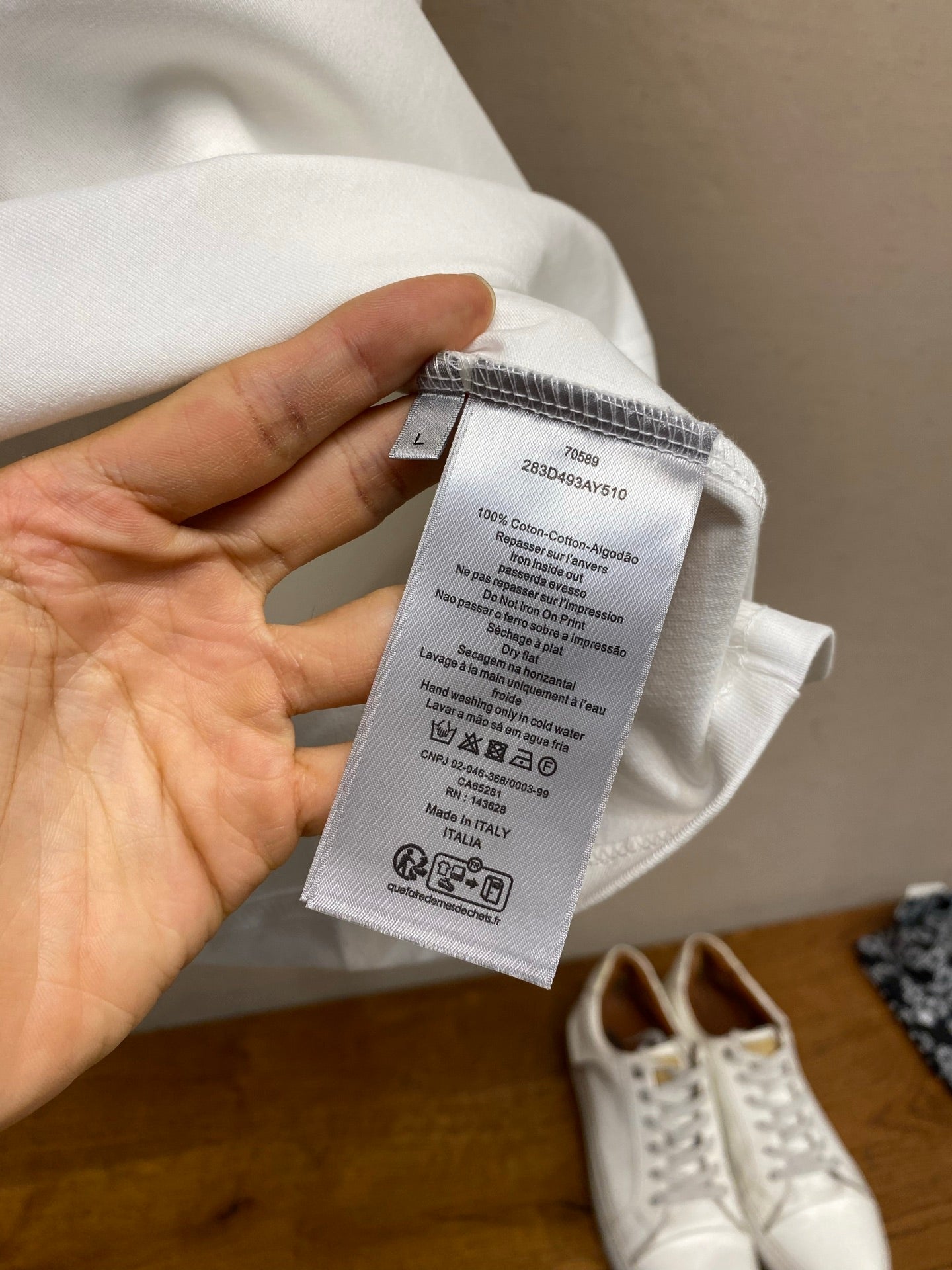White T-shirt care label tag held against the fabric