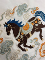 Embroidered horse and cloud motifs on a white T-shirt