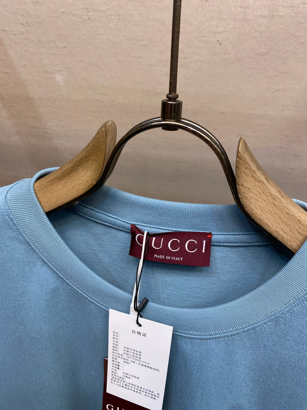 Light blue Gucci crew-neck T-shirt collar with red Gucci label tag