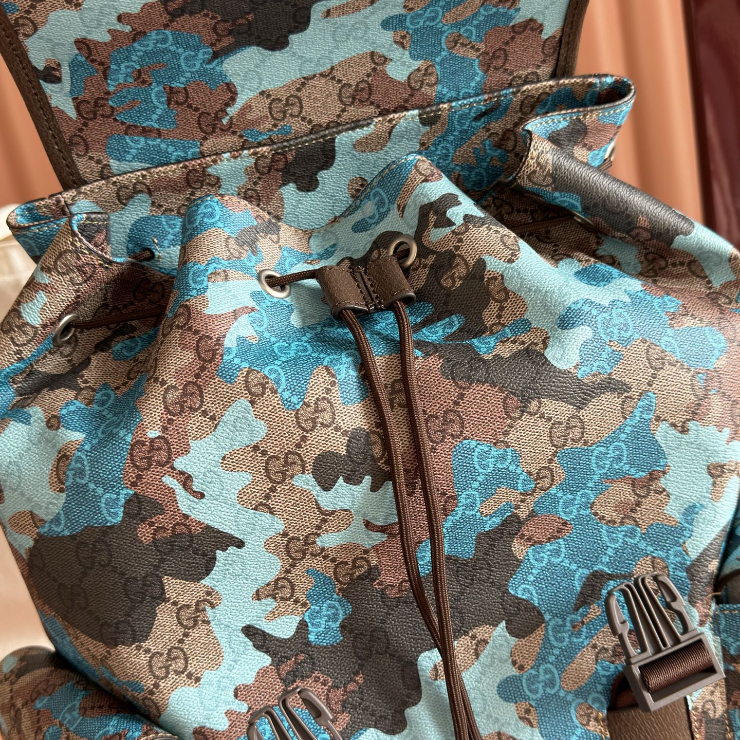 Gucci camo-print backpack with drawstring tie, zipper pulls, and branded front detail