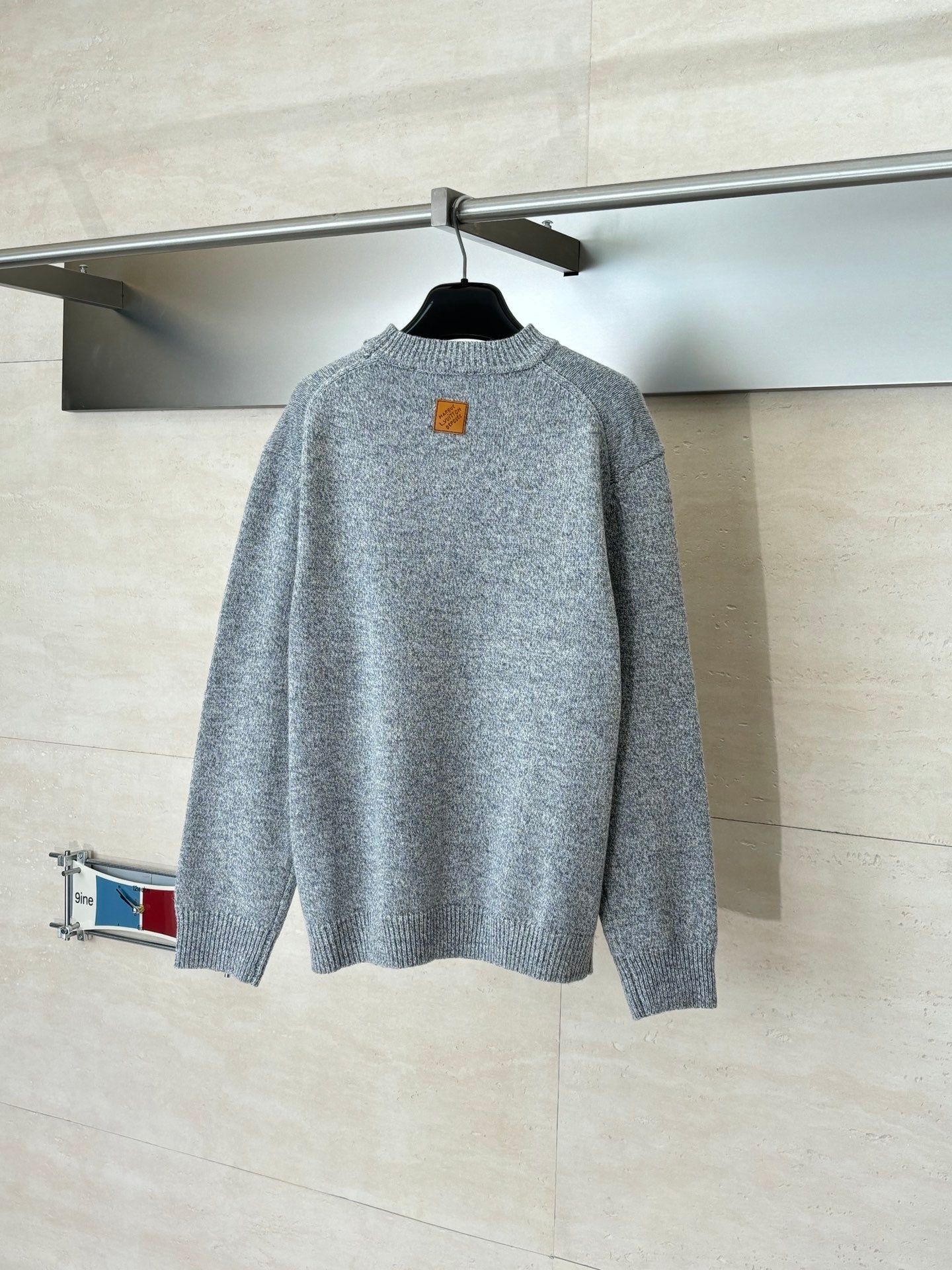 Gray knit sweater back view with small chest tag near collar
