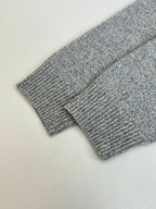 Gray knit sweater sleeve close-up with fine textured knit pattern