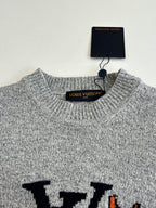 Gray knit sweater neckline with ribbed collar and hang tag labeled Louis Vuitton
