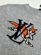 Gray knit sweater front graphic detail with orange and black cartoon-style letters