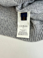 Gray sweater interior care label tag with size and fabric info