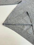 Gray knit sweater sleeve and hem close-up with ribbed knit cuff