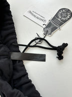 Black shorts with drawstring ties and hang tags attached to waistband